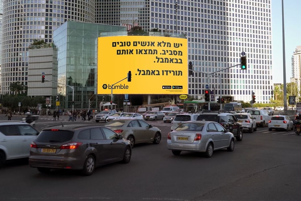 שלט חוצות דיגיטלי צהוב בצומת מרכזי